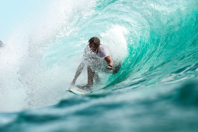 Photo d'un surfeur dans une vague, métaphore de l'artiste dans un océan de disciplines artistiques