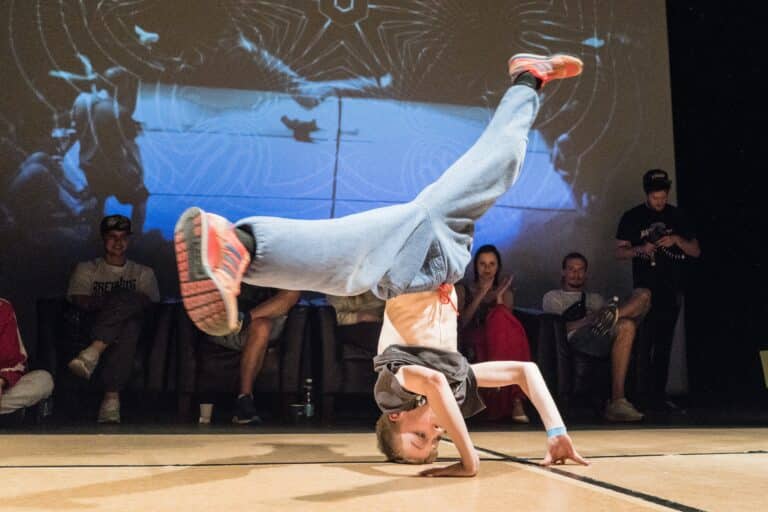 Un jeune enfant fait une figure de street dance pendant une représentation